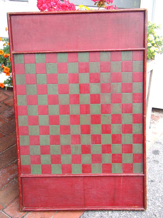 An antique folk art pine double sided games board in green and red paint circa 1890